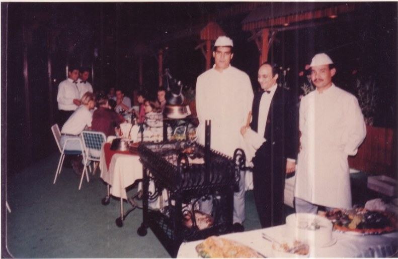 Archive photograph of the Saturday grill being served on the rooftop, chefs in whites beside the trolley
