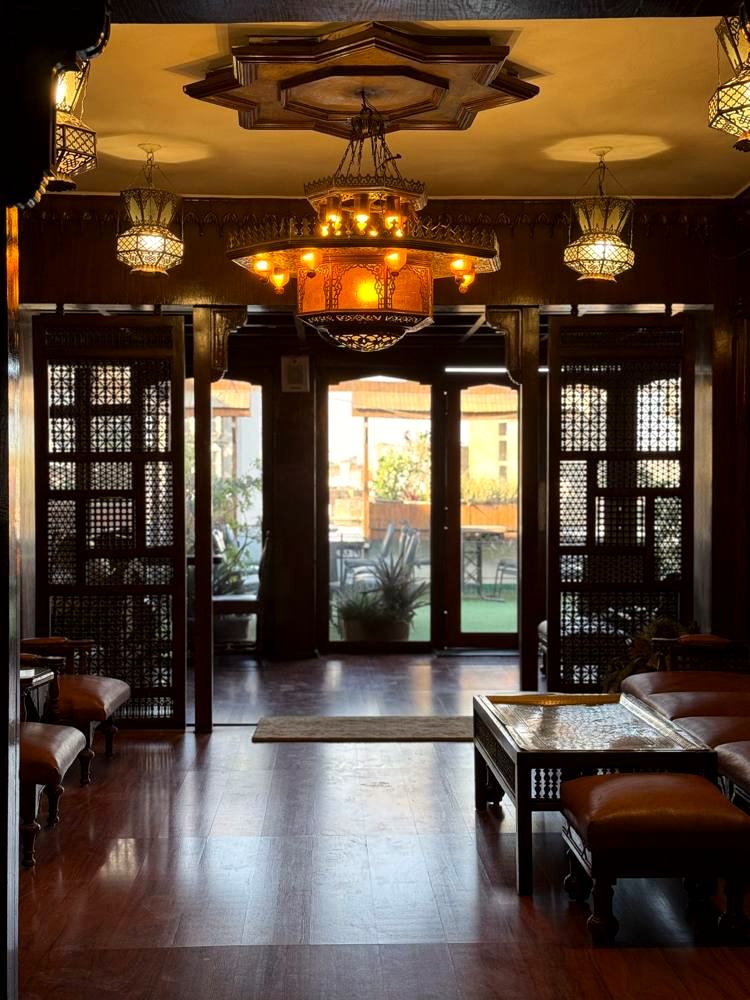 The lobby with its star-shaped carved ceiling and brass lanterns