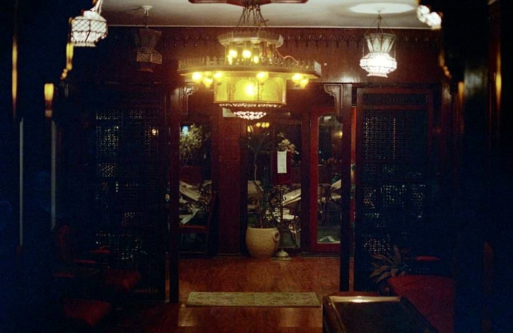 Rooftop at night with a large brass lantern and mashrabiya screens