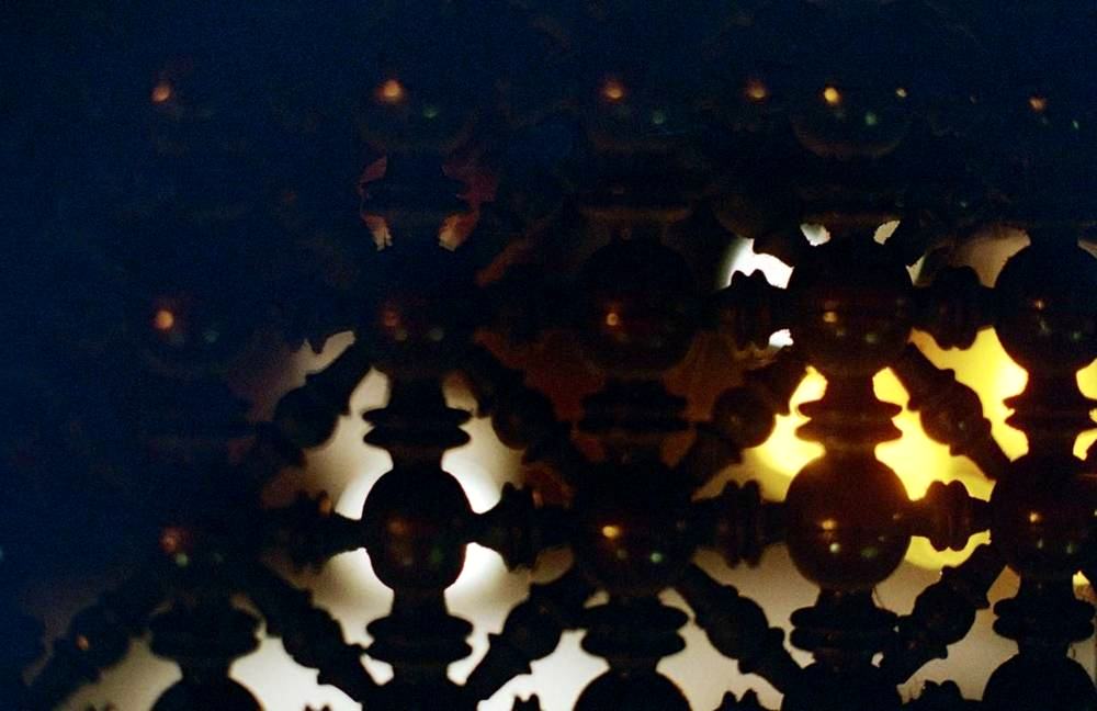 Close-up of turned-wood mashrabiya lattice, back-lit by lamps