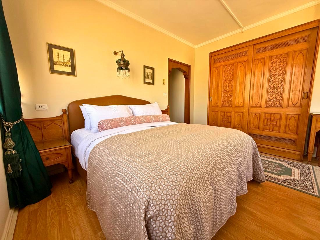 Double room with a double bed, carved wardrobe and green curtains