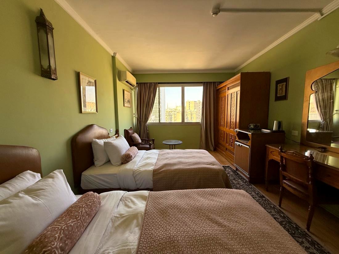 Twin room with two single beds, a desk and a window over Downtown