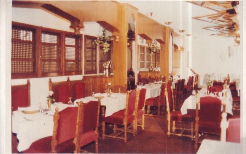 Archive photograph of the dining room with red chairs and white tablecloths