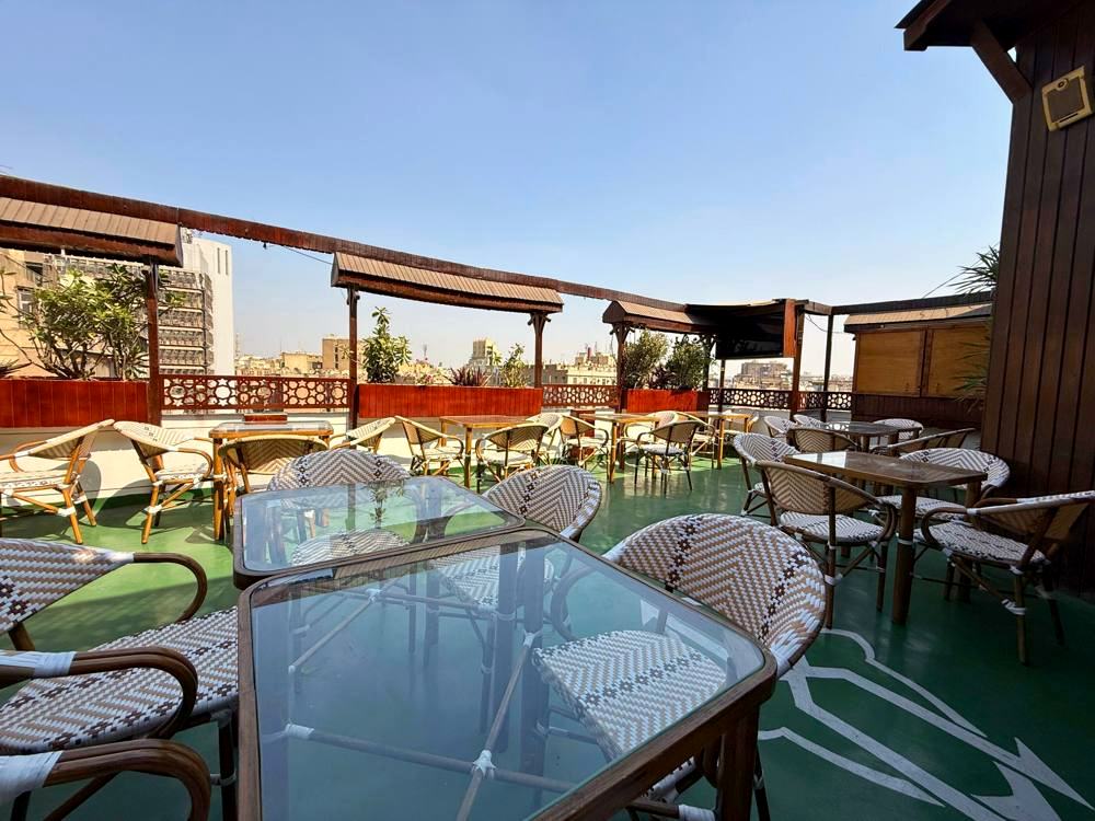 The rooftop terrace today, tables under the same pergola with Downtown beyond