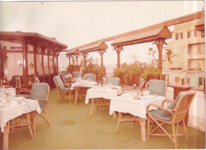 Archive photograph of the rooftop terrace, tables laid under a timber pergola